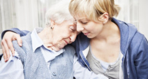 home caregiver consoling sad senior woman