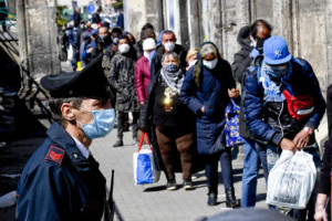 The Carabinieri maintain order among the many people lined up at the soup kitchen of the 'Carmine Maggiore' church in Naples, Italy. In the aftermath of the Covid-19 pandemic, many canteens for the poor have been closed and those that are open must feed many more people, 4 april 2020 ANSA / CIRO FUSCO